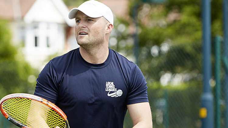 Man who works for Local Tennis Leagues holding a tennis racket
