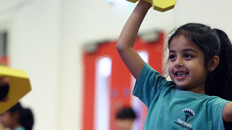 A young girl enjoying a tennis based game at school