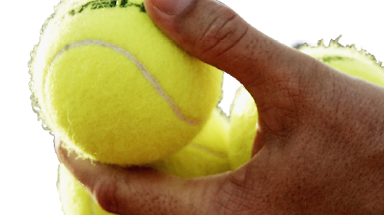 Cut out of tennis balls being held by a person