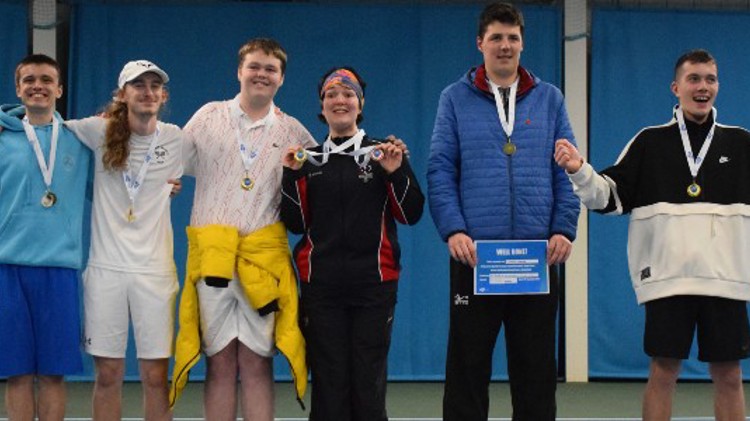 wining players standing in a line with medals around their neck and two with certificates in hand
