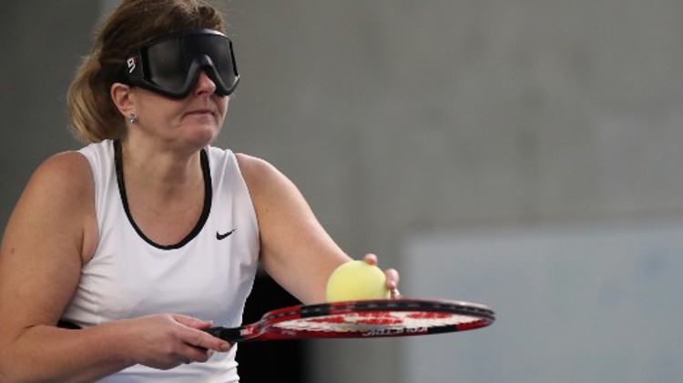 virtually impaired woman holding ball on racket