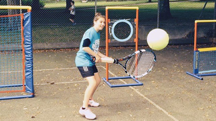 Roxanne Marshall hitting a backhand with a large racket and ball
