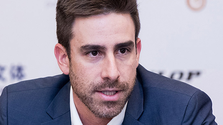 A close up of Luiz Procopio Carvalho in a suit