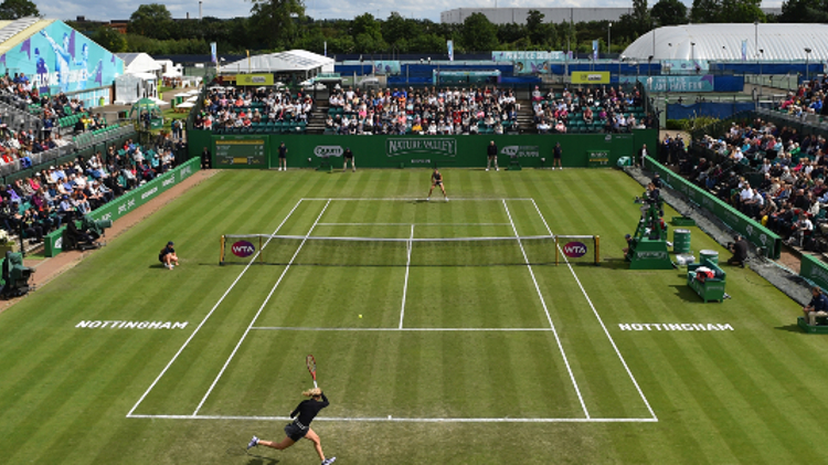 An action shot of two players on court with spectators in the stands