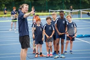 Coach leading school tennis session