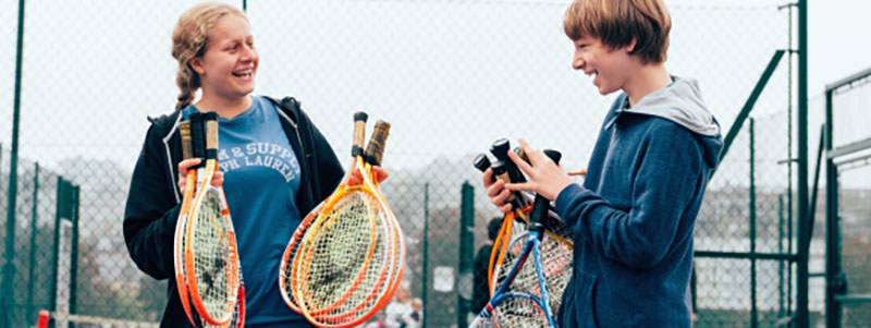 People holding tennis rackets and smiling