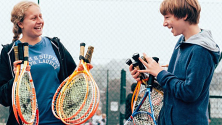 People holding tennis rackets and smiling