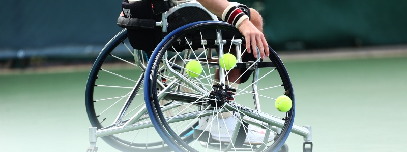 Wheelchair close up with tennis balls in air