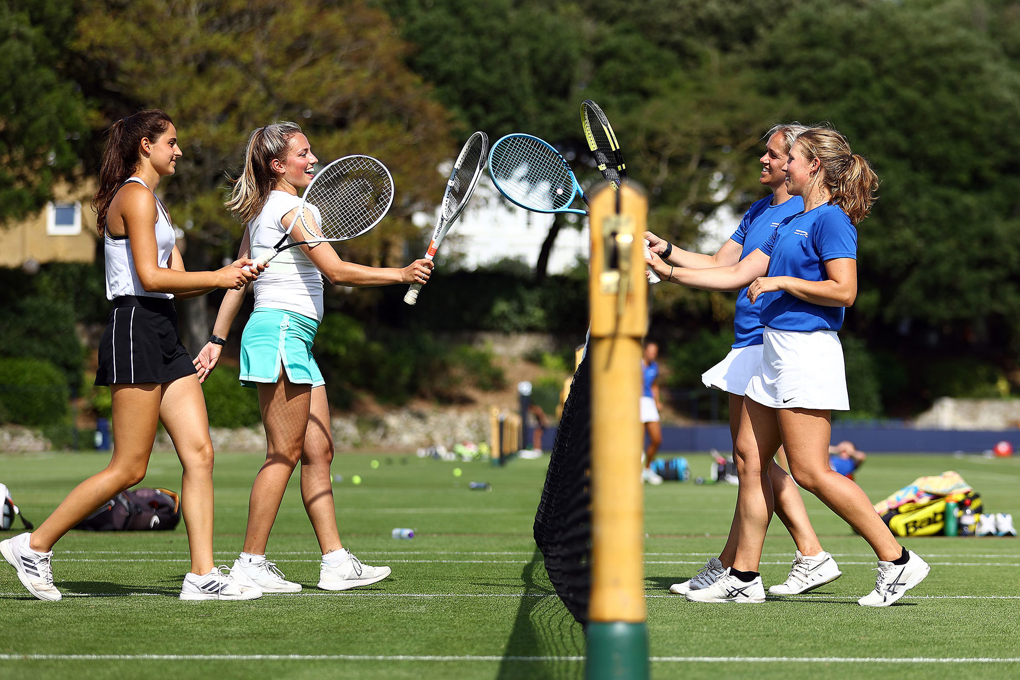 Four female tennis players cheering each other
