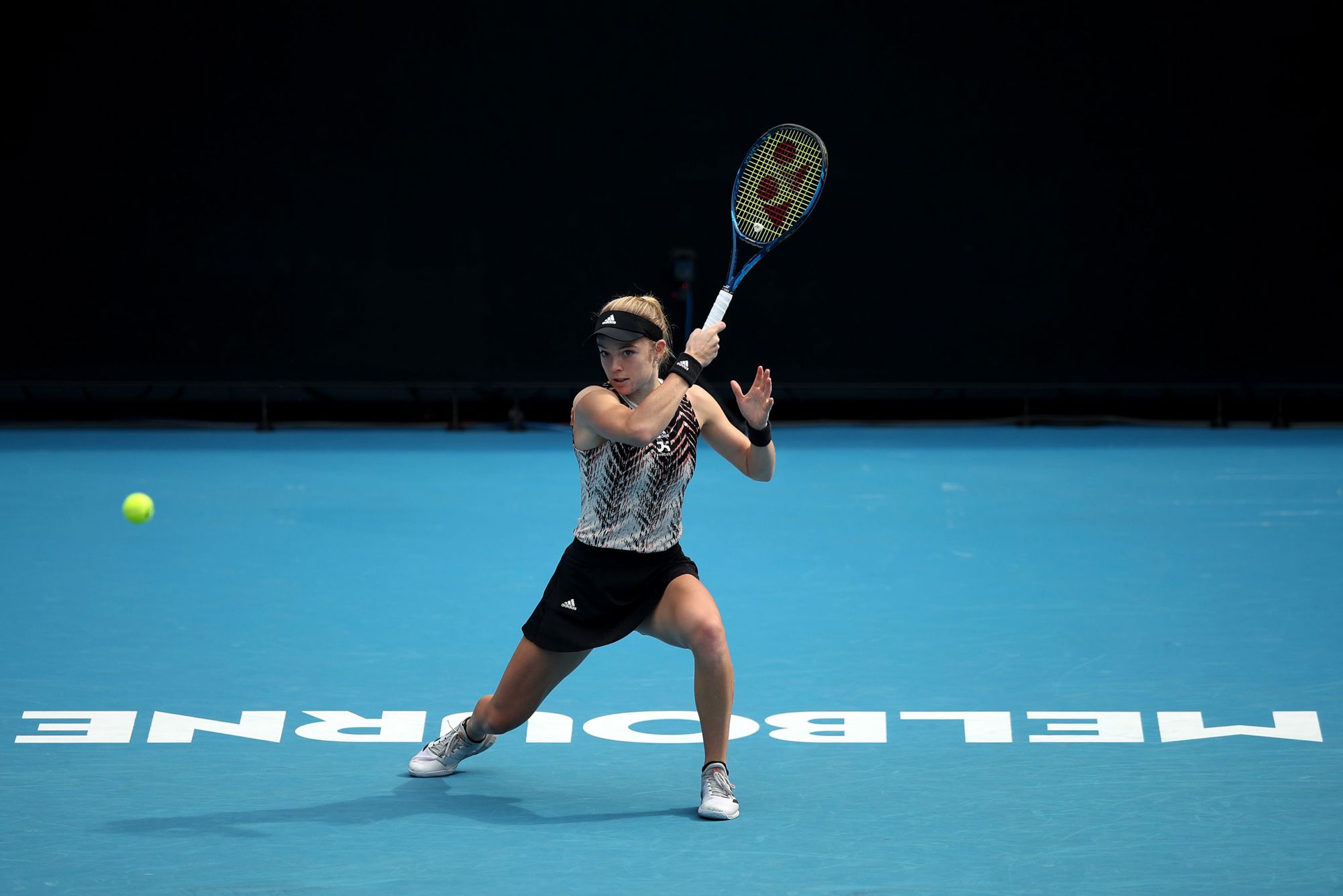Female holding a tennis racket over her head