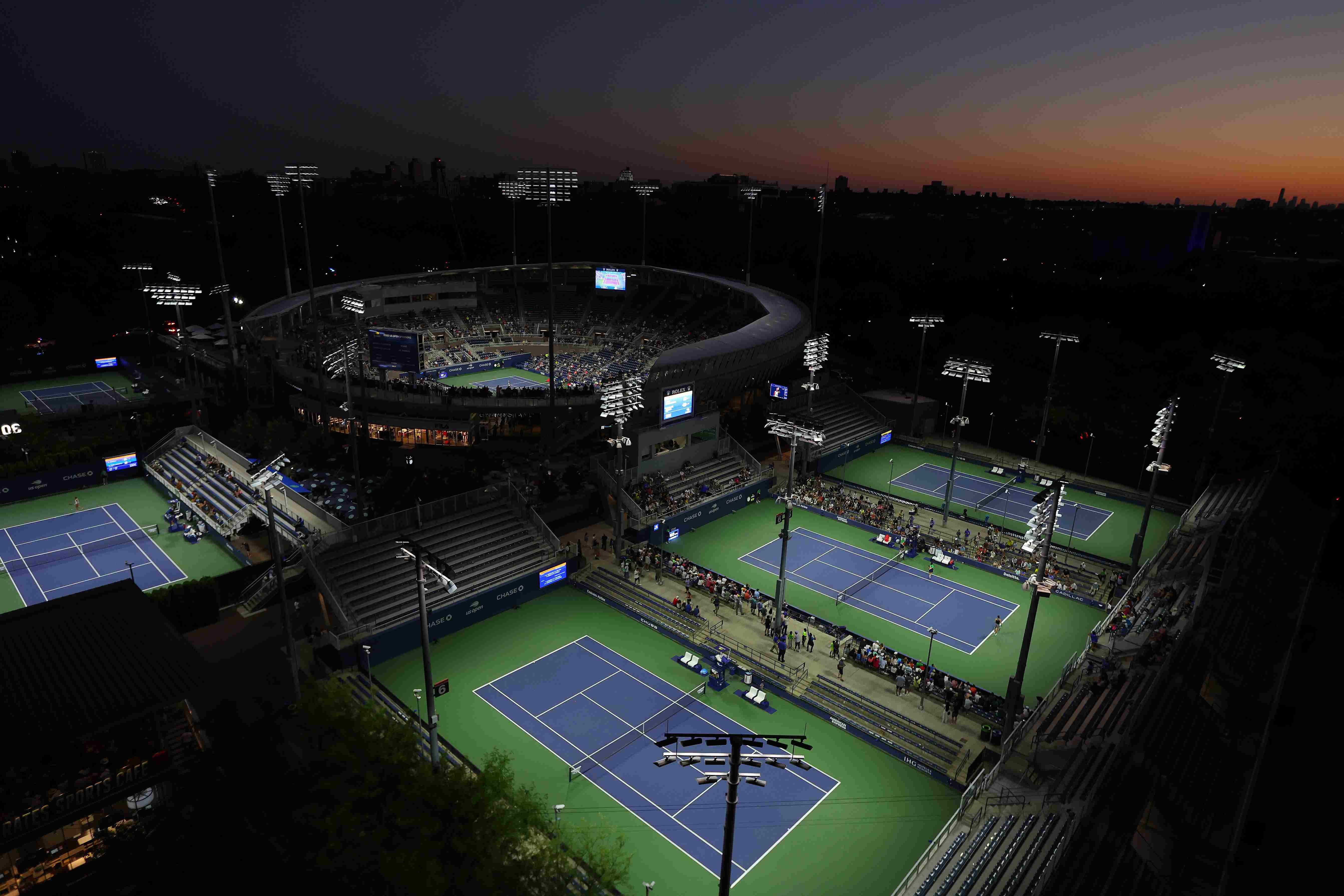 Four tennis courts surrounding Arthur Ashe Stadium at the US Open complex