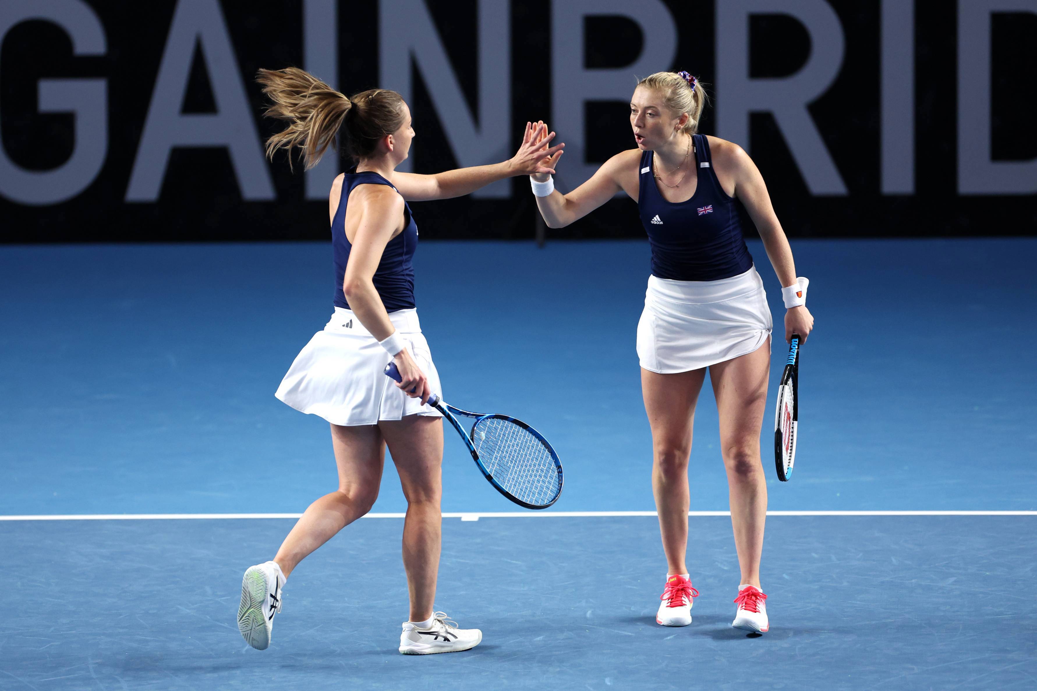 Olivia Nicholls & Alicia Barnett high-fiving on court at the Billie Jean King Cup Qualifiers against France