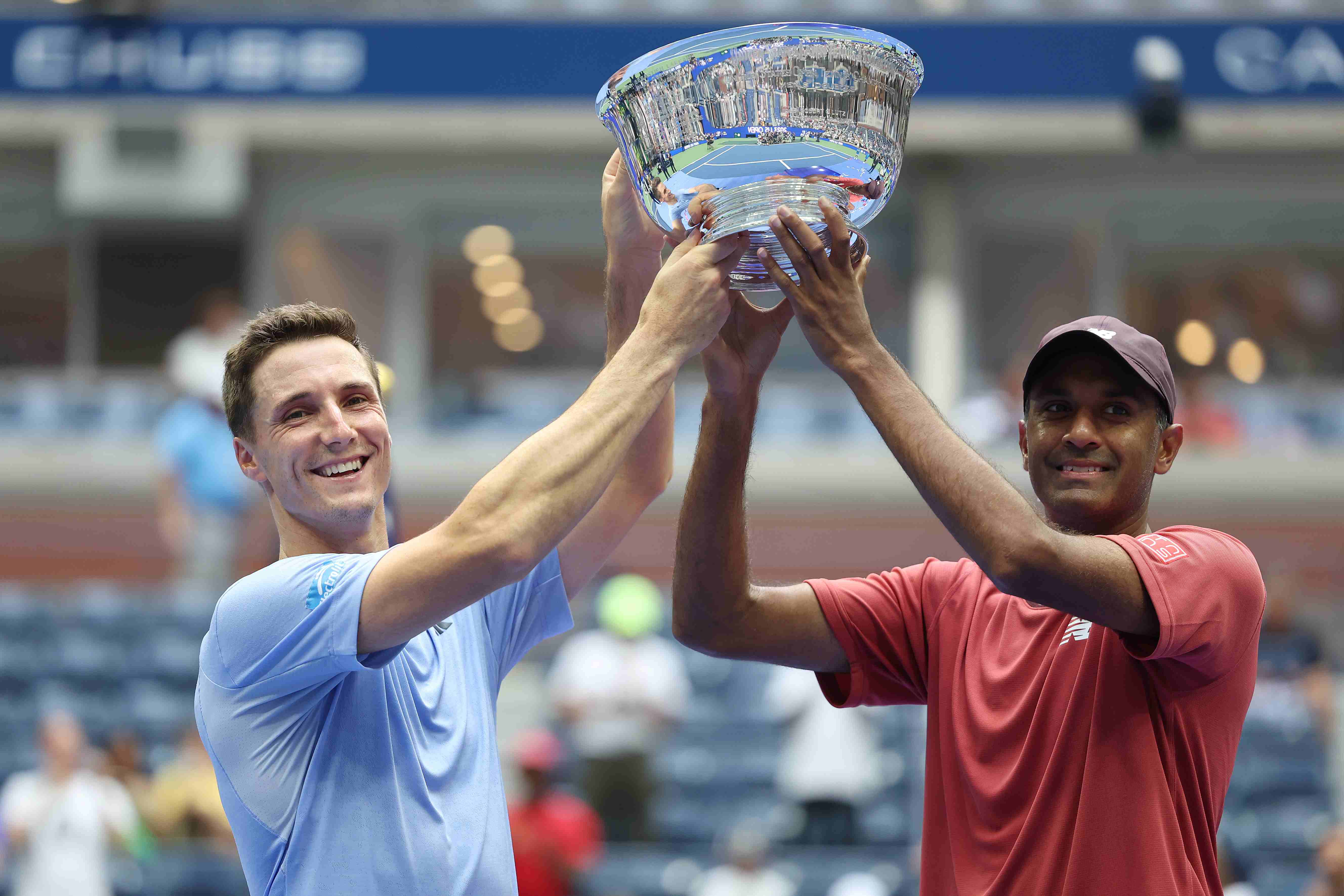 Joe Salisbury and Rajeev Ram lifting their championship trophy on court at the US Open