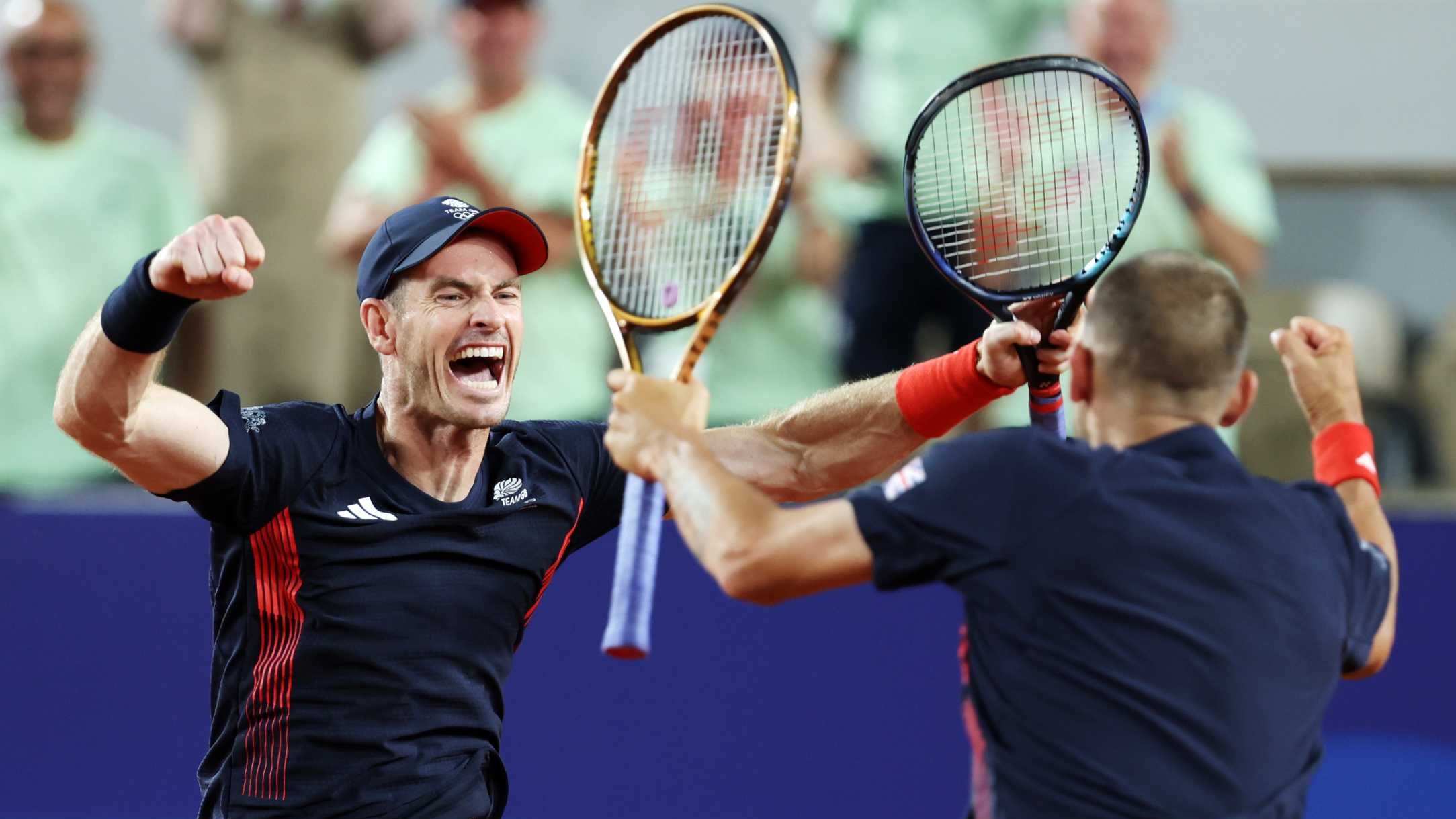 Andy Murray screaming and cheering alongside Dan Evans while holding their tennis rackets