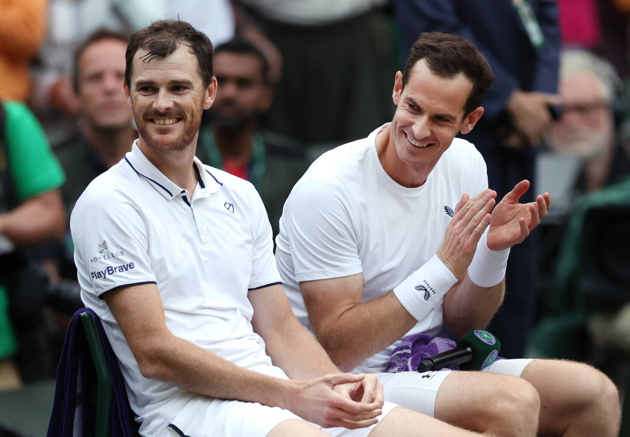 Jamie and Andy Murray laugh on court after their first round Wimbledon doubles match