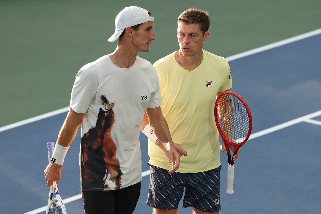 Joe Salisbury and Neal Skupski talking on court during their third round win at the 2025 US Open