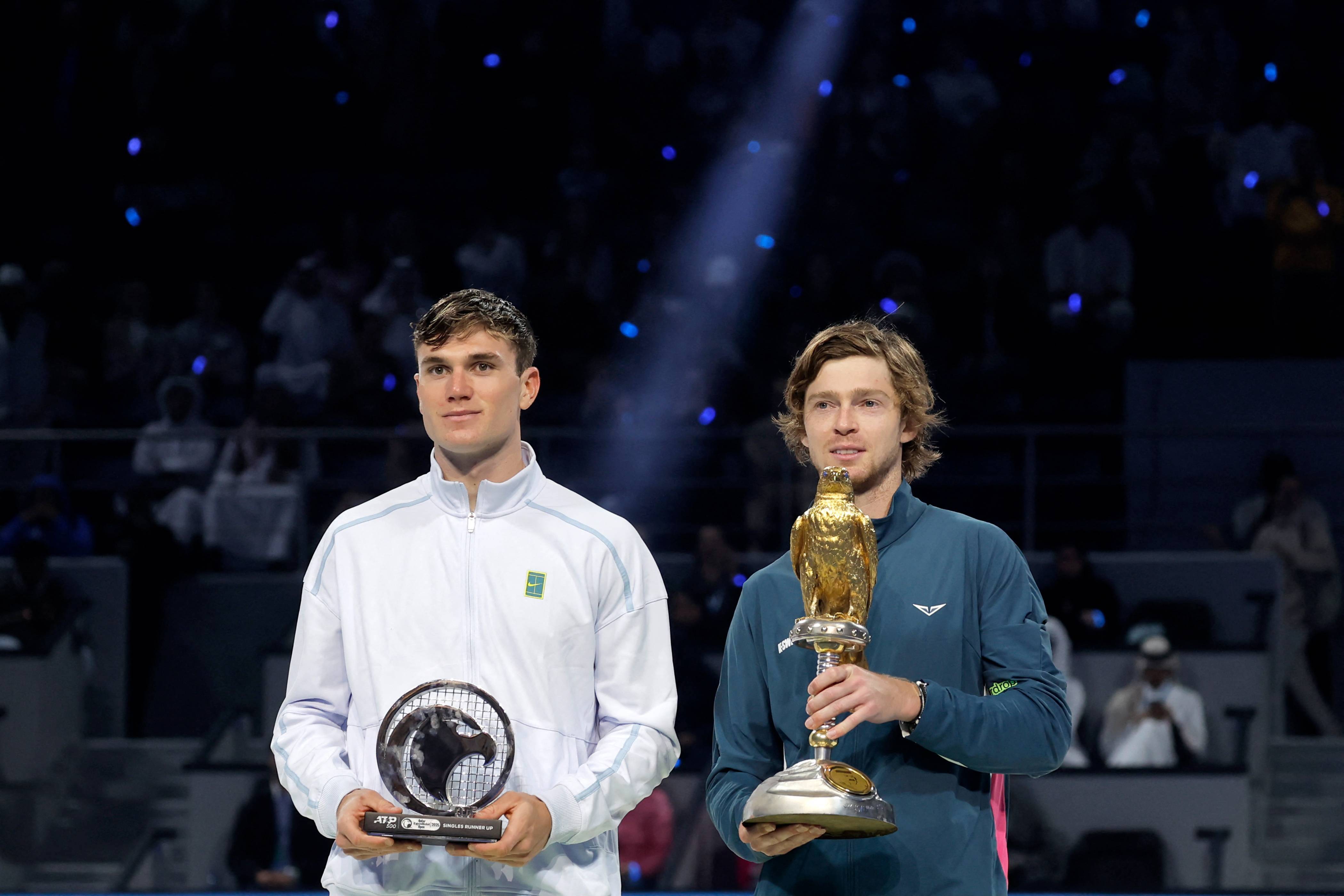 Jack Draper with the Qatar Open runner-up trophy next to champion Andrey Rublev 