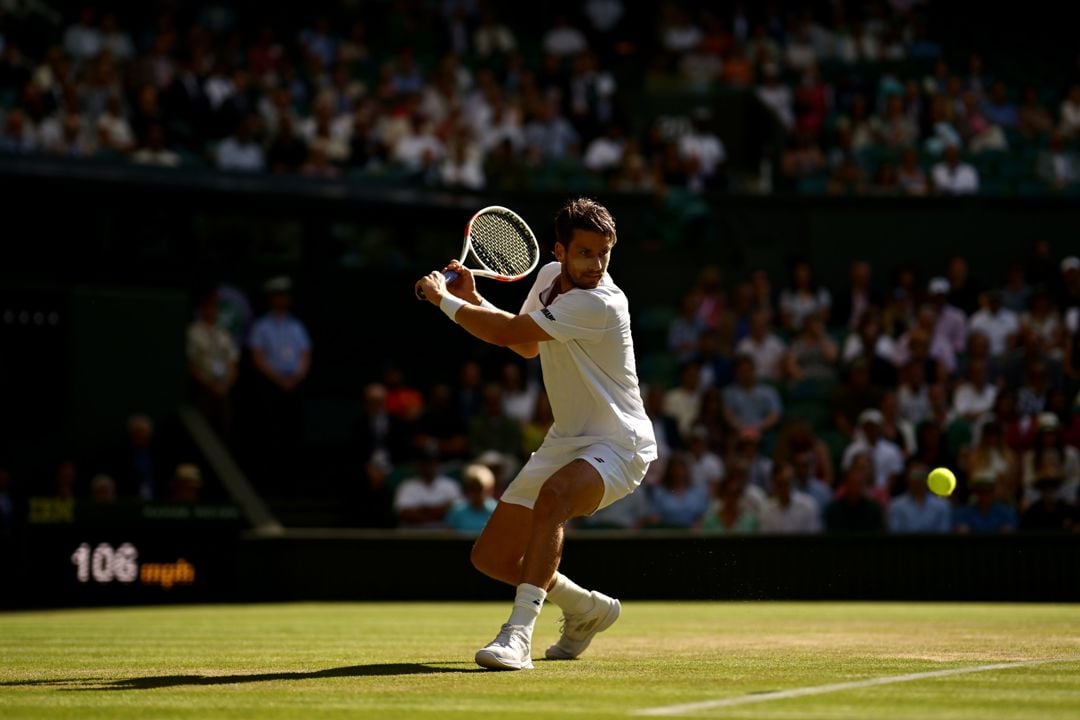 Cam Norrie about to hit a back hand in front of the Wimbledon crowd