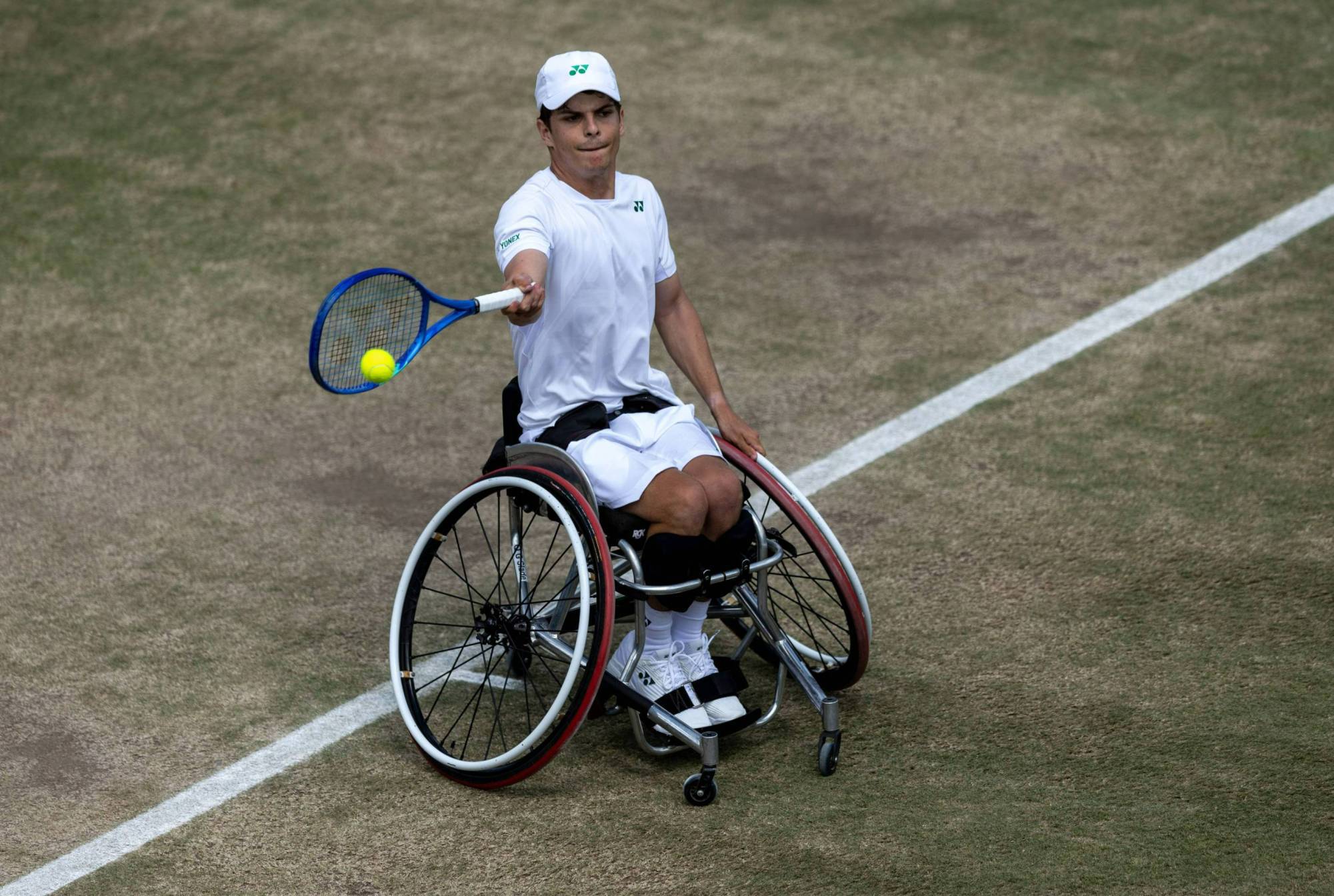 Greg Slade hitting a forehand on a grass court