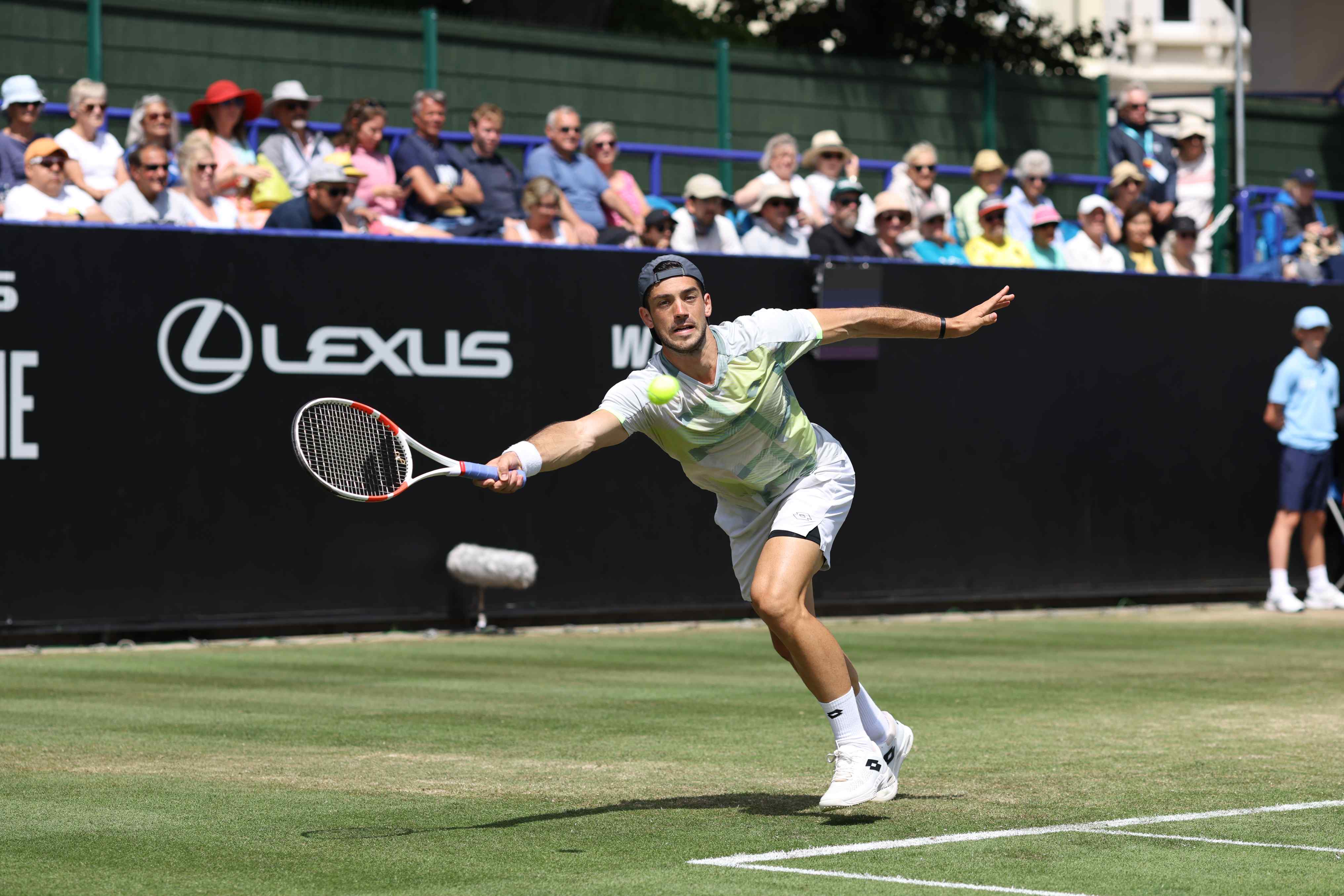 Julian Cash reaching to hit a forehand on court at the Lexus Eastbourne Open