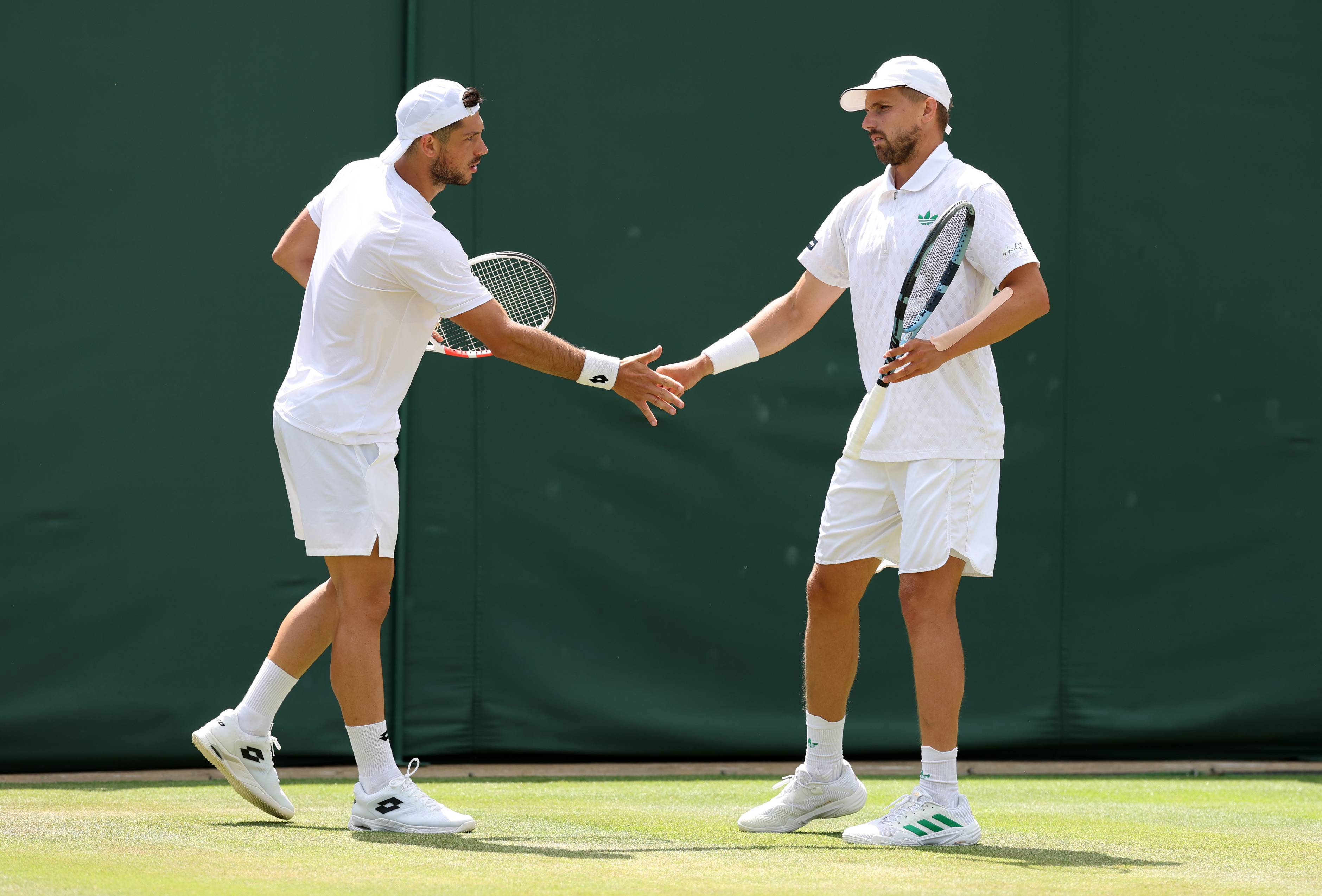 Julian Cash and Lloyd Glasspool high five in the quarter-finals at Wimbledon