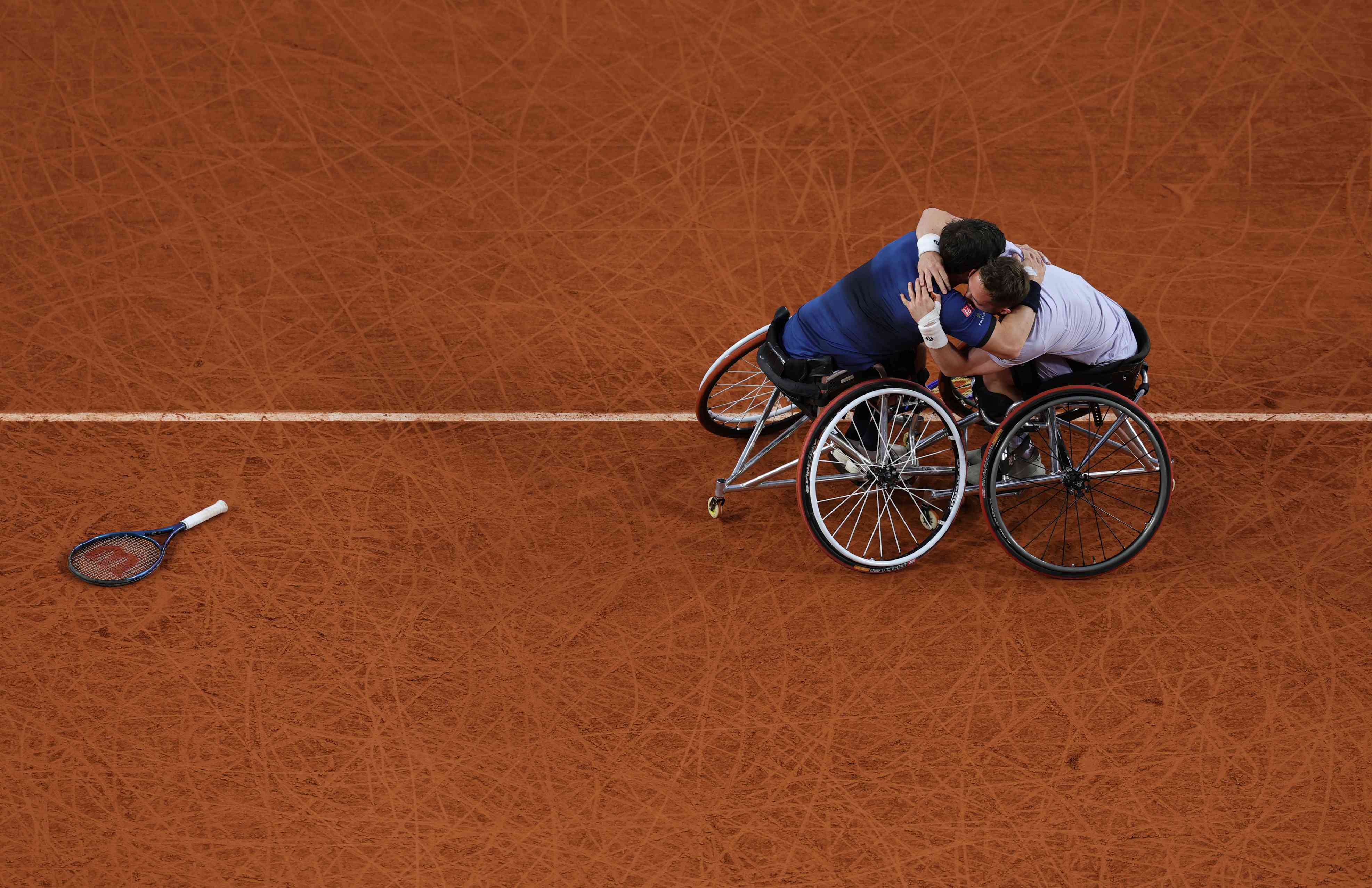 Alfie Hewett and Gordon Reid hugging each other on court at Roland Garros