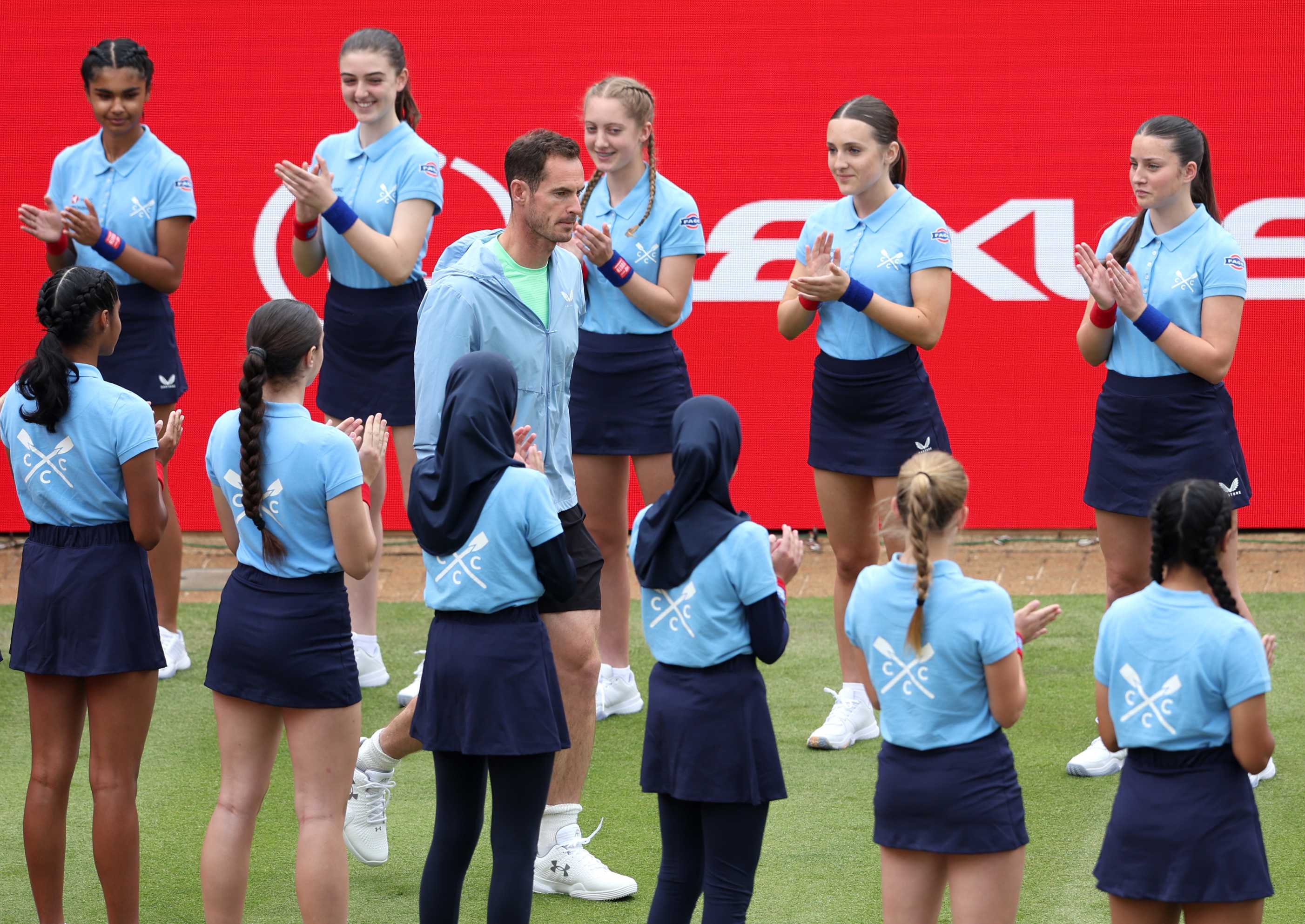 Andy Murray being surrounded and clapped by the ball kids as he walks onto the Andy Murray Arena at the HSBC Championships