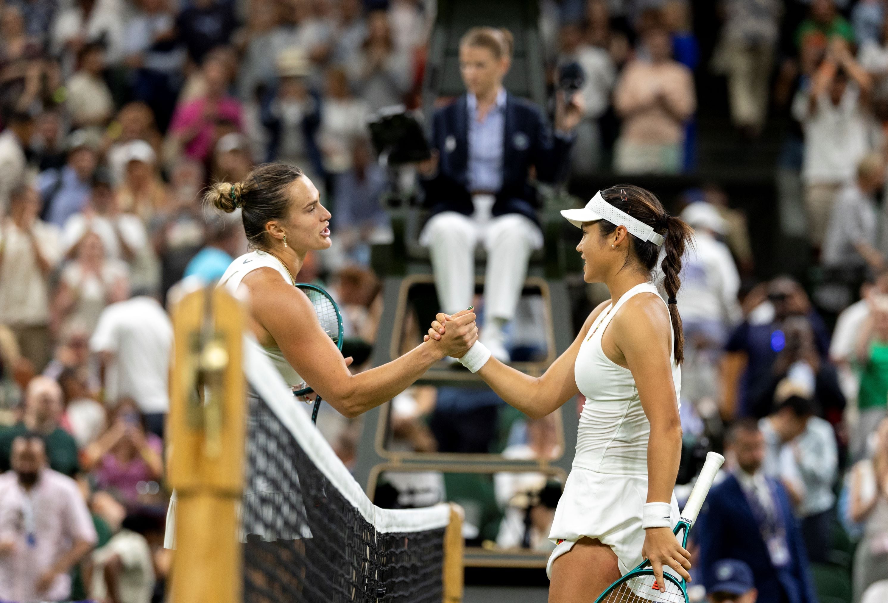 Emma Raducanu shakes hands with Aryna Sabalenka over the net after their third round match at Wimbledon