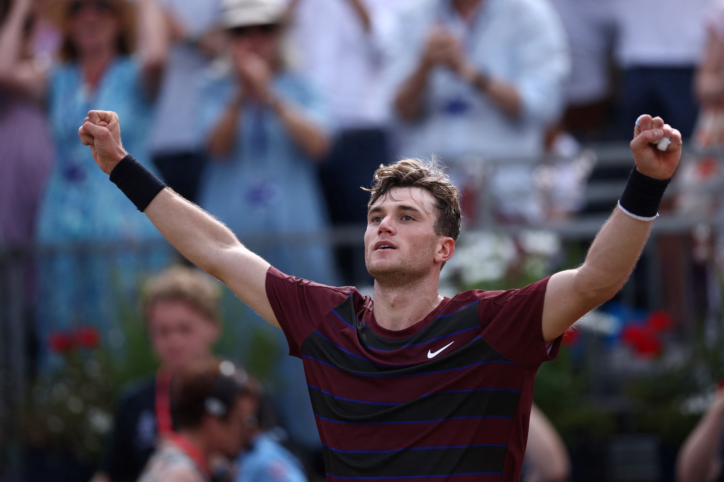 Jack Draper with both hands in the air celebrating a win