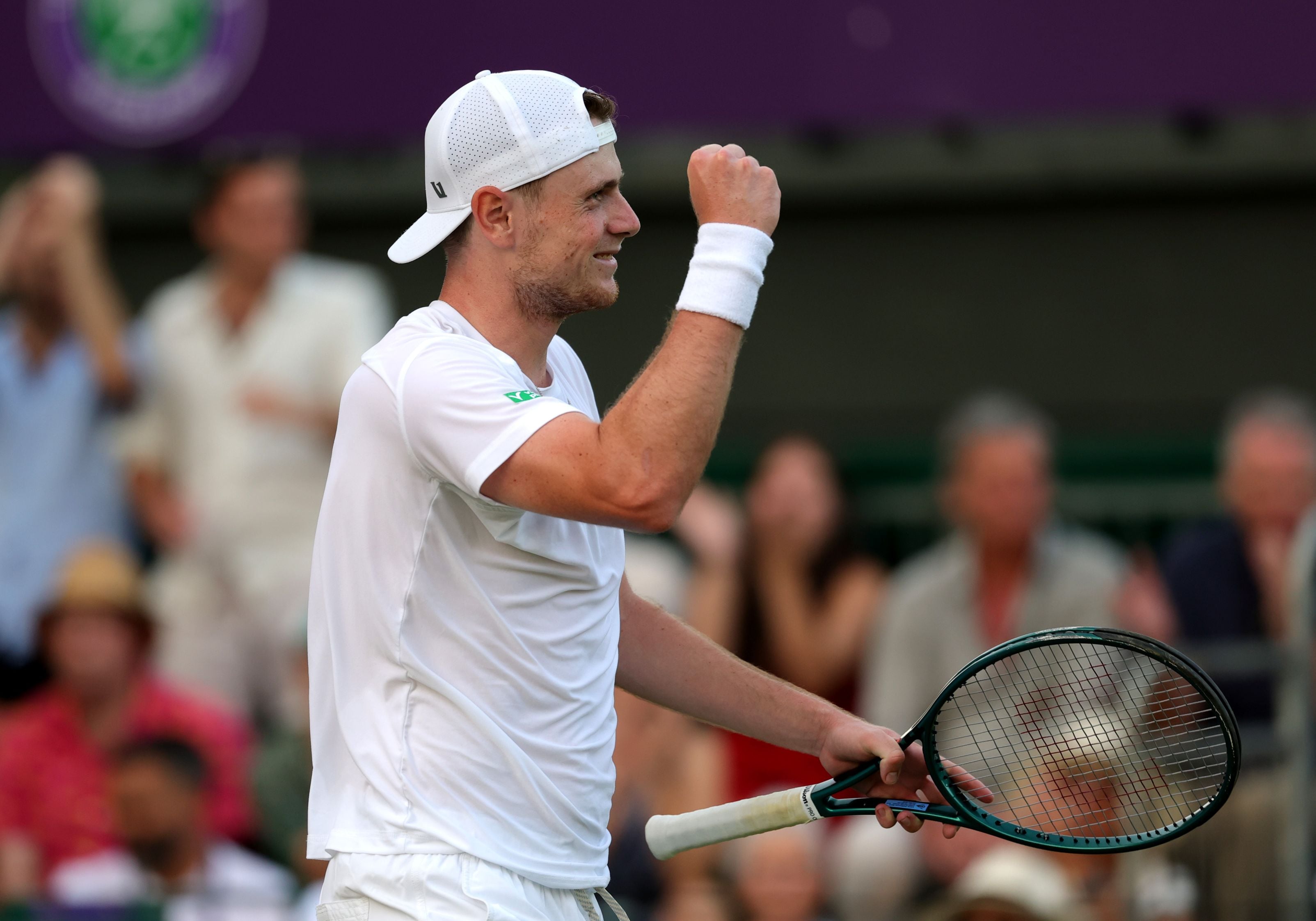 Jack Pinnington Jones smiling while holding his tennis racket after winning his first round match at Wimbledon