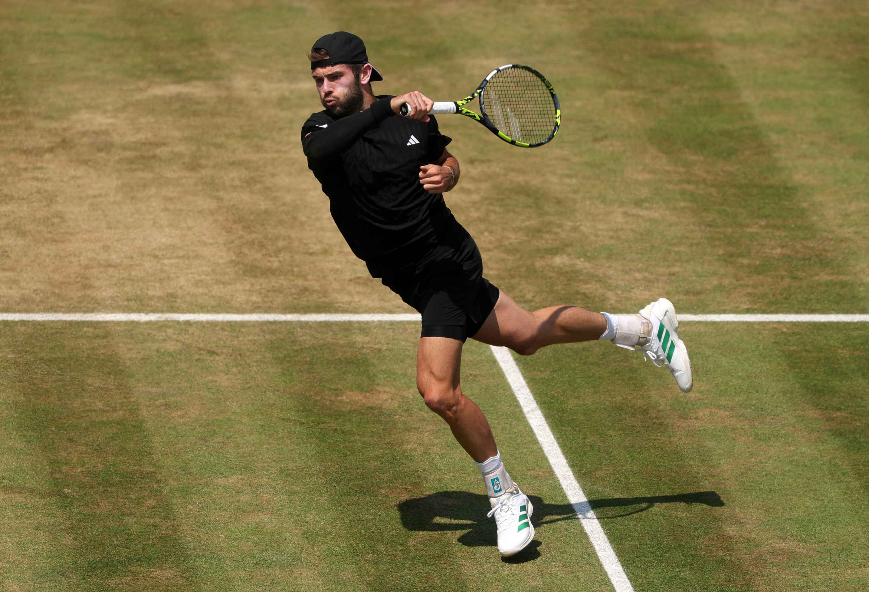 British tennis player Jacob Fearnley hitting a forehand on a grass court at the HSBC Championships
