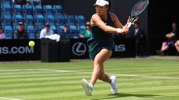Mimi Xu about to hit a low backhand on the grass at the Lexus Birmingham Open