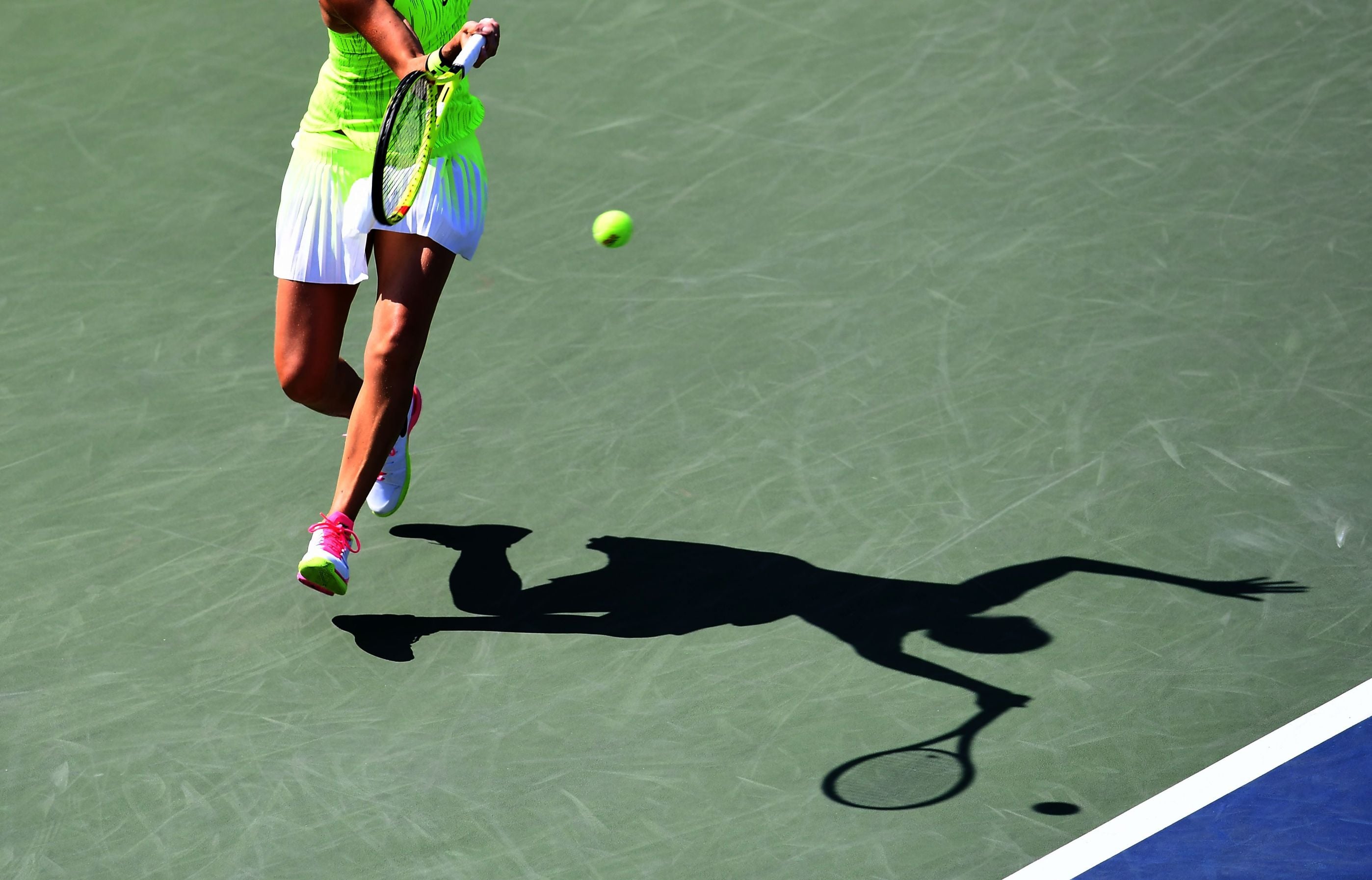 A female tennis player hitting a shot on a hard court