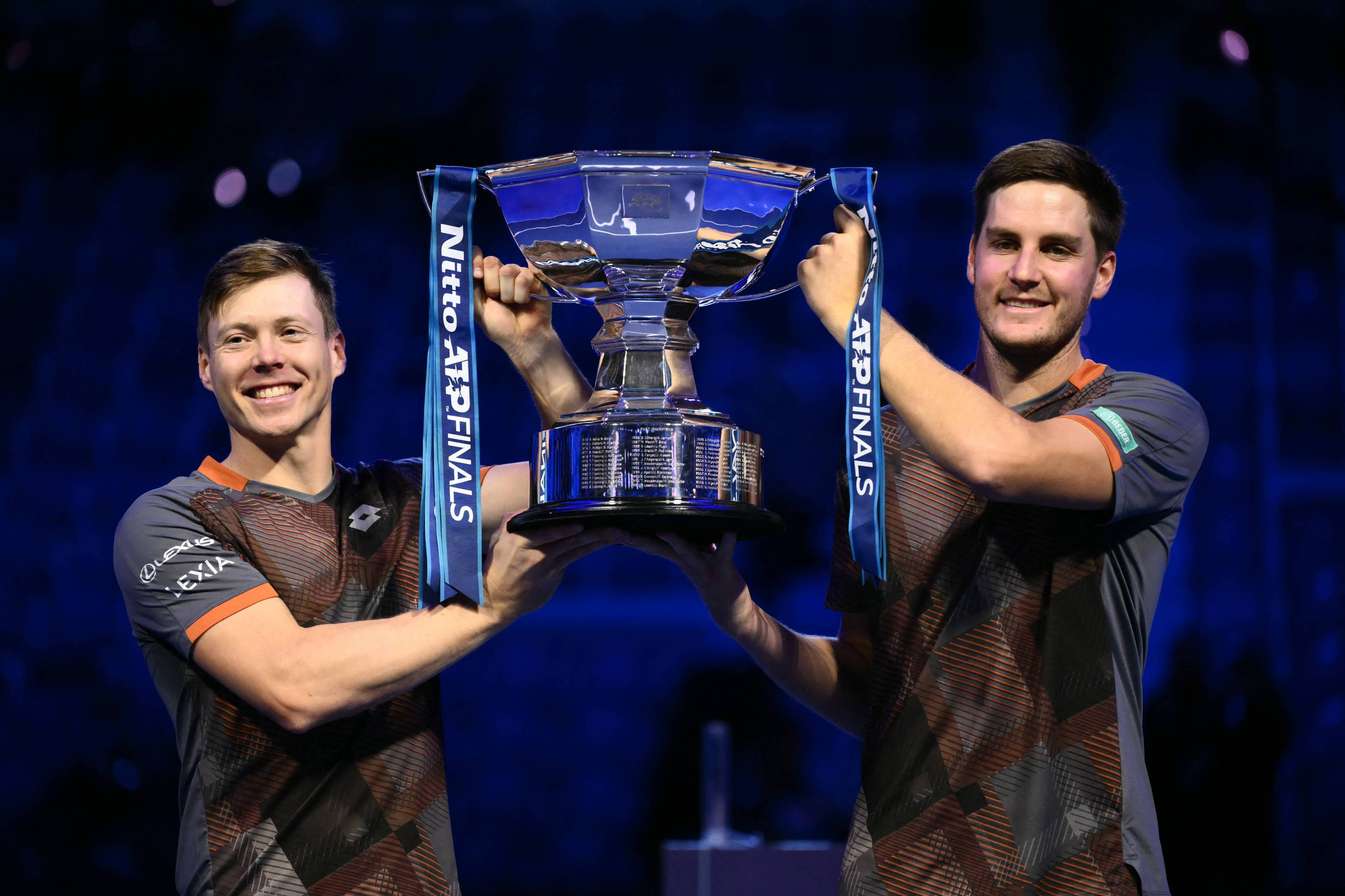 Harri Heliovaara and Henry Patten holding the 2025 Nitto ATP Finals title