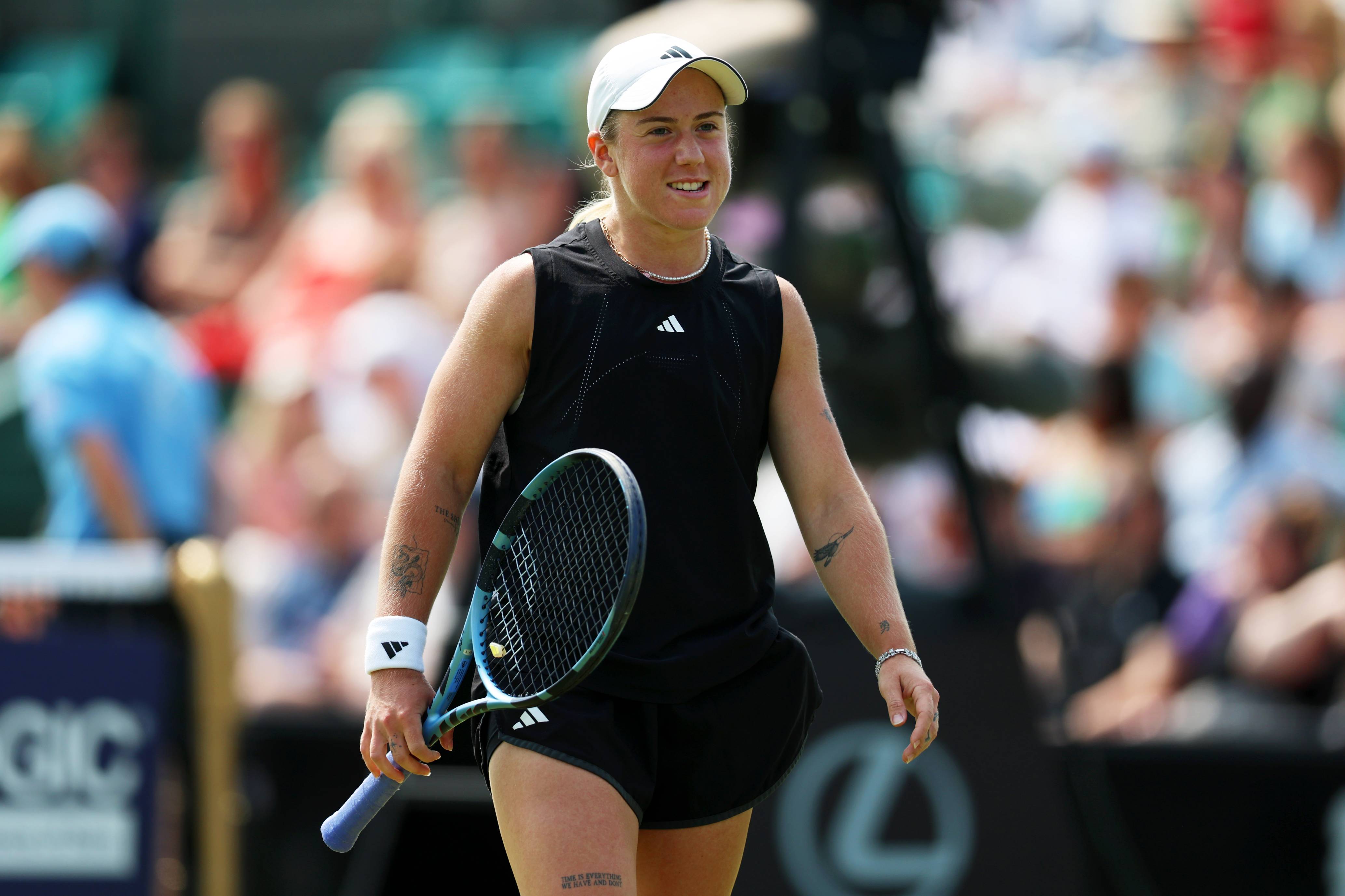 Sonay Kartal smiling and holding her tennis racket on court at the Lexus Eastbourne Open