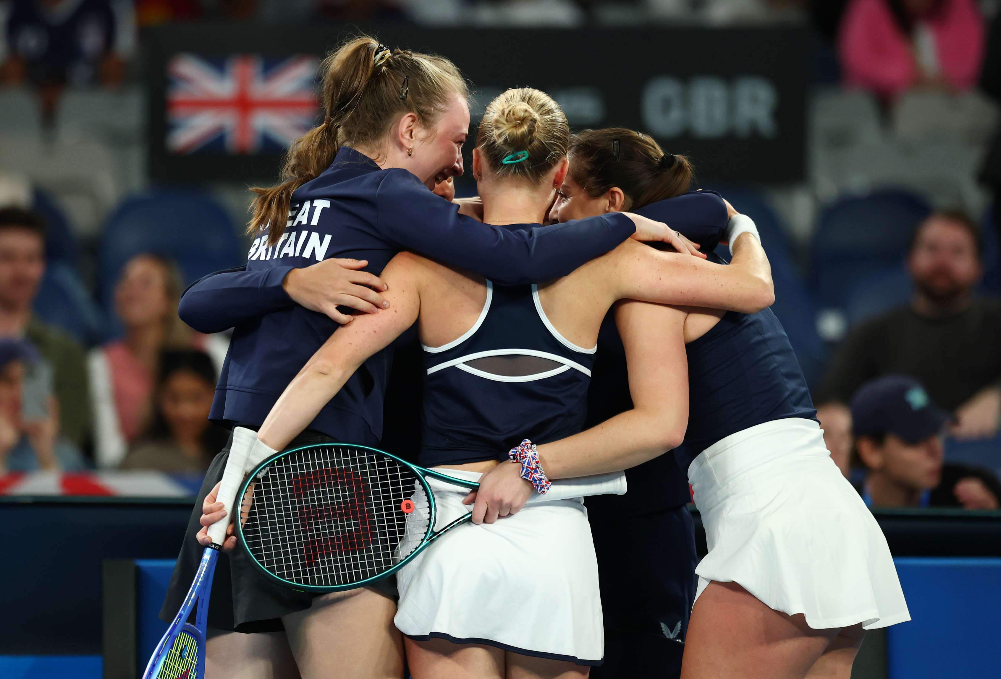 The Great Britain Billie Jean King Cup team hug in celebration after beating Australia