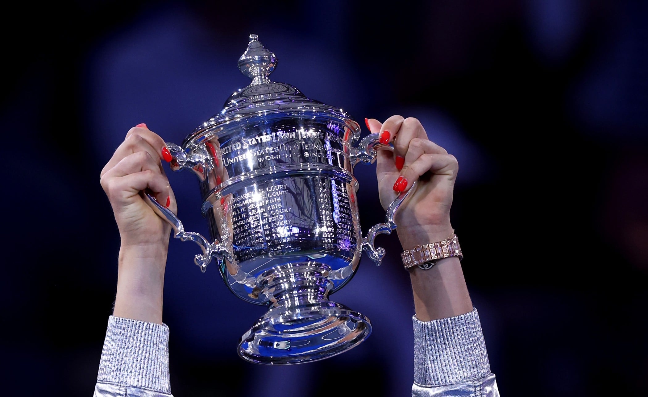 Women's US Open trophy being held in the air