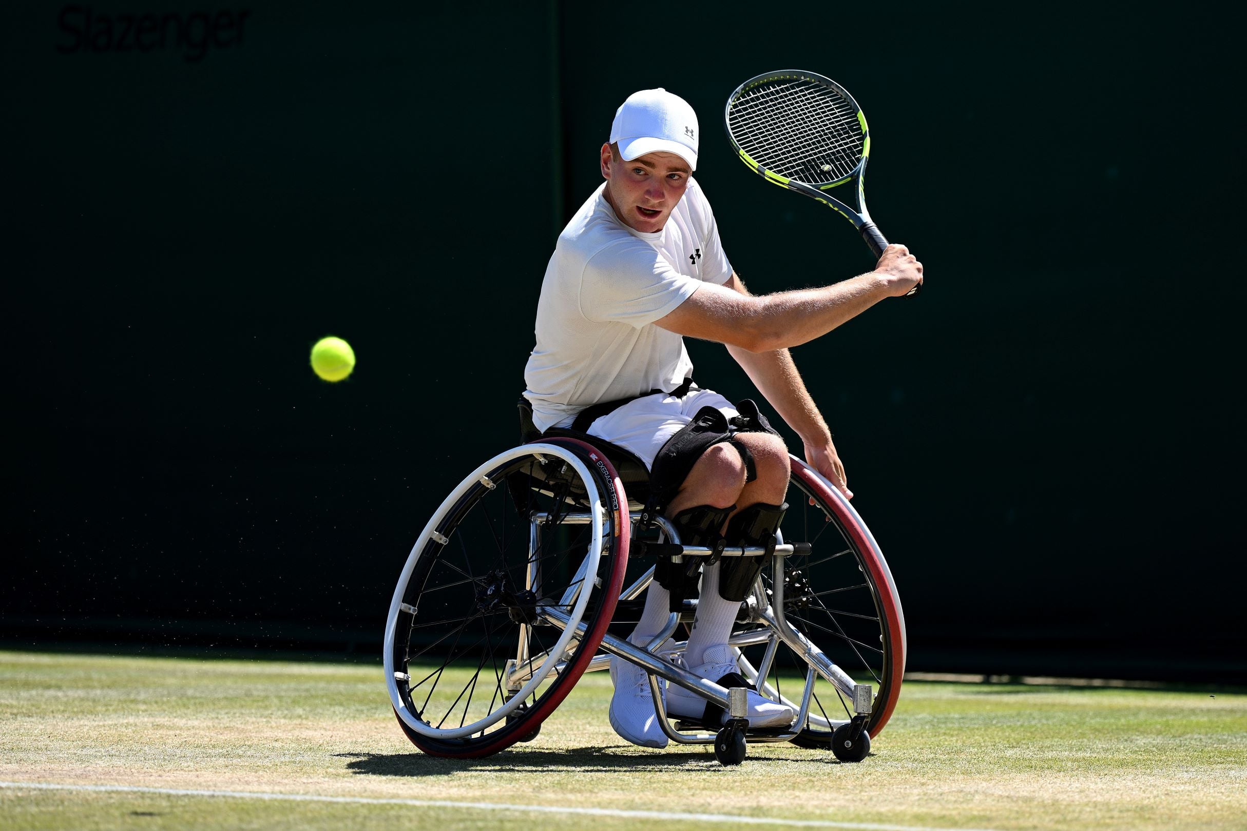 Wheelchair tennis star Andrew Penney about to hit a backhand on the grass