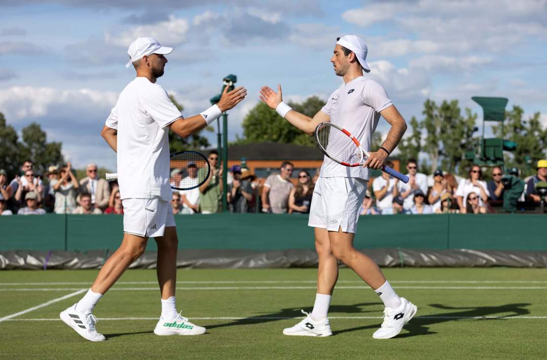 Julian Cash and Lloyd Glasspool high five after a point at Wimbledon