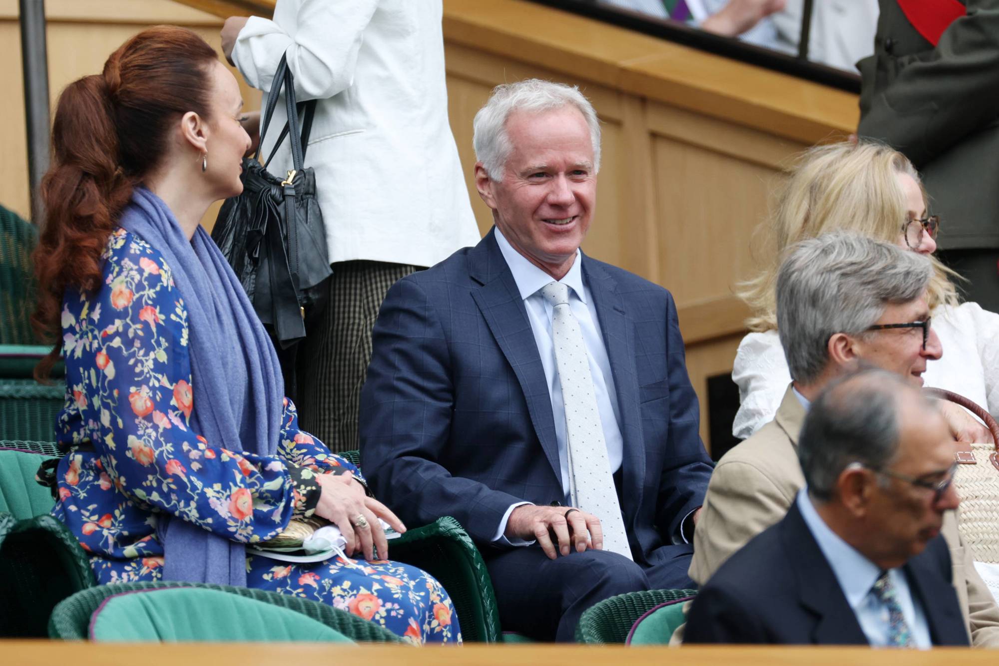 Former American tennis player Patrick McEnroe smiling while sat in the Royal Box on Centre Court