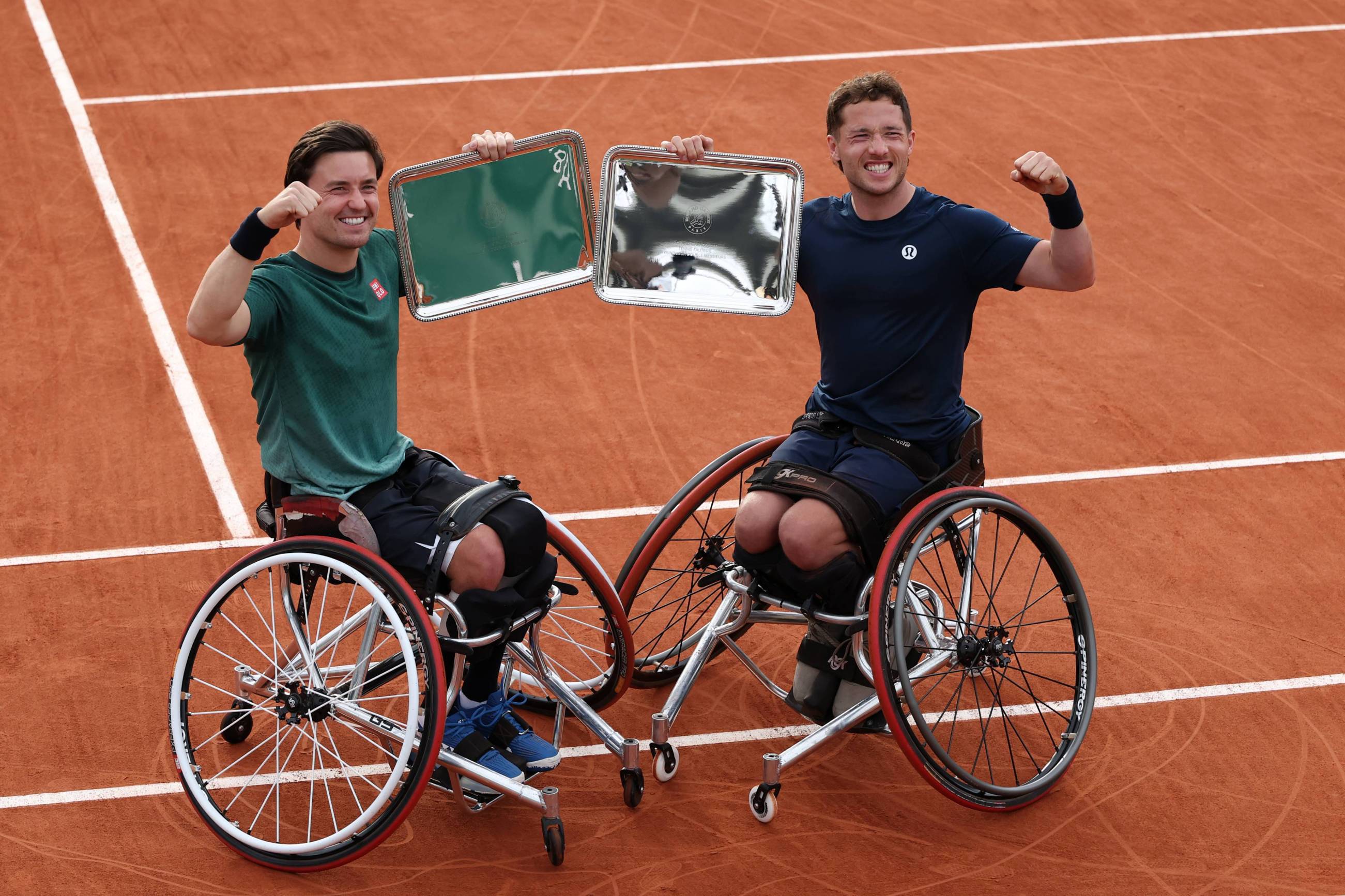 Alfie Hewett and Gordon Reid holding their champions trophy at Roland Garros after capturing their seventh French Open doubles title