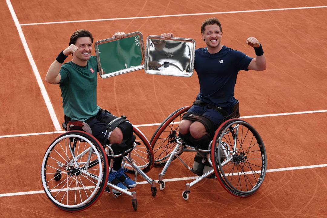 Alfie Hewett and Gordon Reid holding their champions trophy at Roland Garros after capturing their seventh French Open doubles title