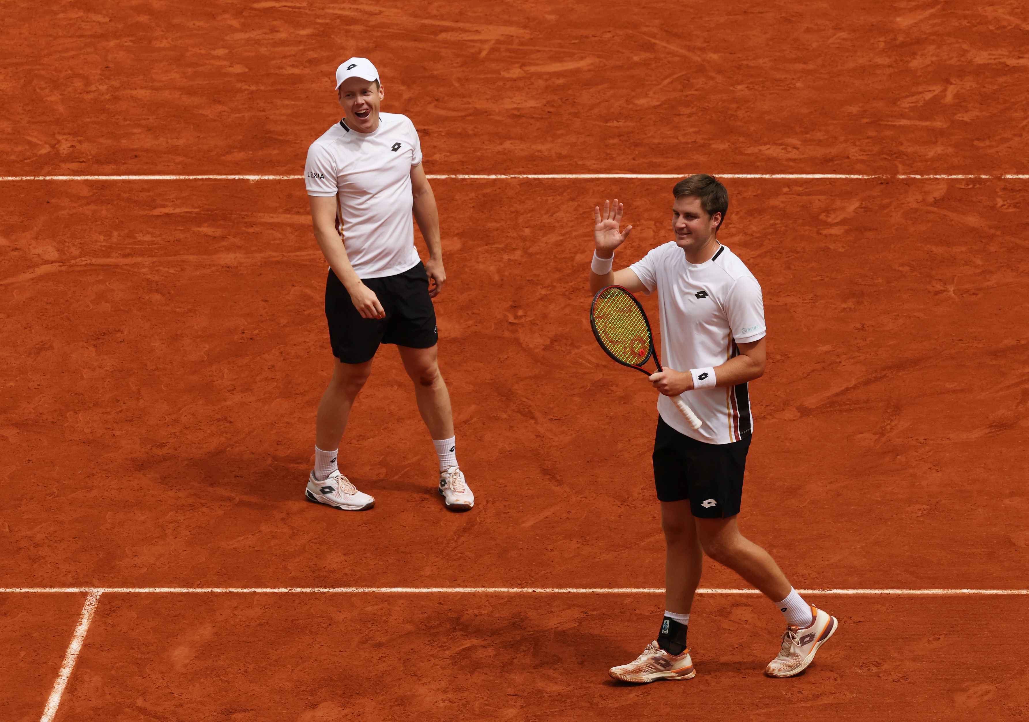 Henry Patten and Harri Heliovaara wave to the crowd in the 2026 Roland Garros semi-final