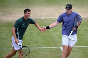 British tennis players Joshua Paris and Ben Jones giving each other a high five on court at the HSBC Championships 