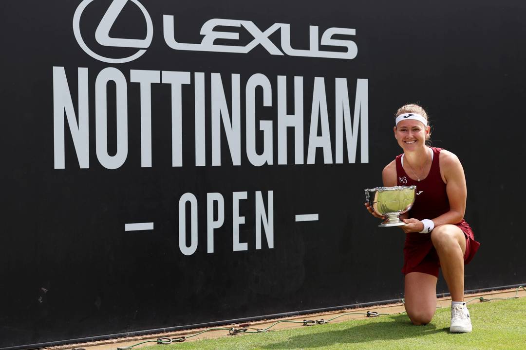 Maria Bouzkova crouching down and holding her Lexus Nottingham Open winners trophy 