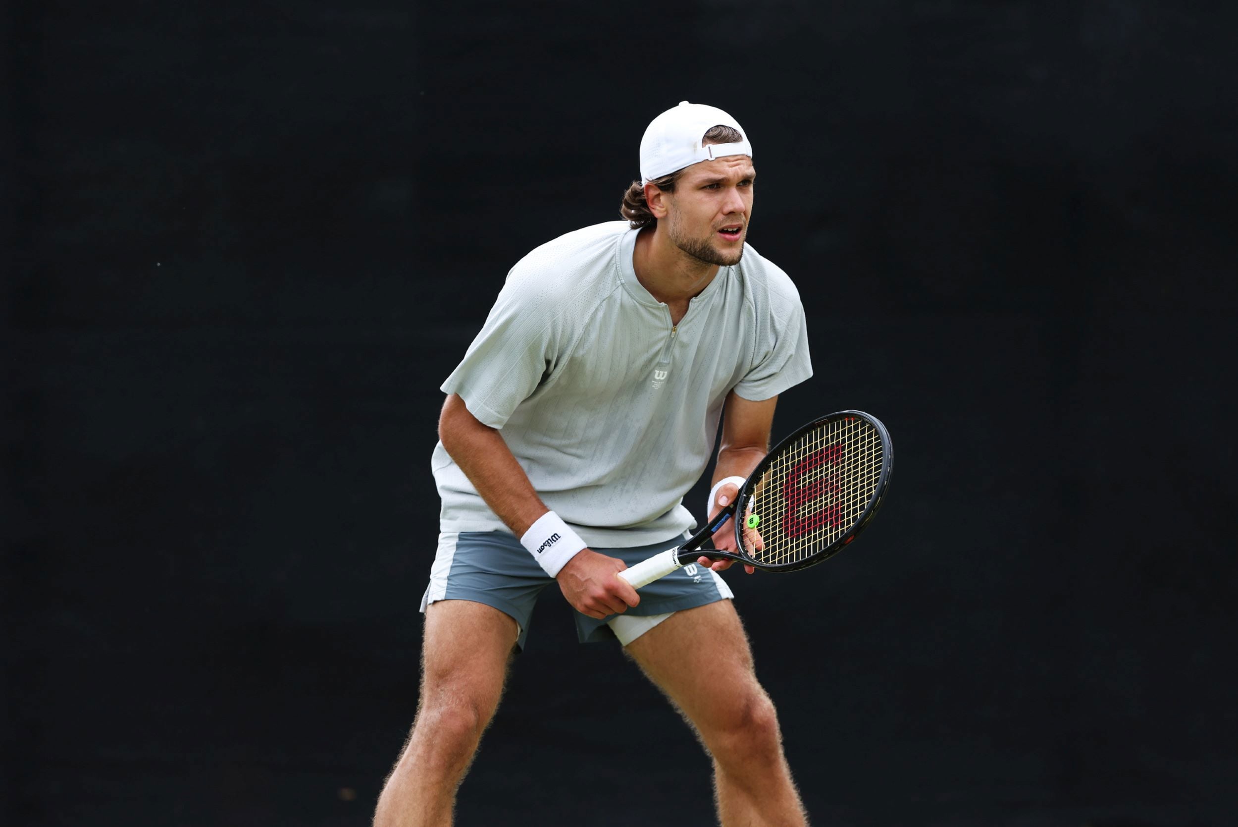 Otto Virtanen standing, ready to play tennis with a racket in his hands