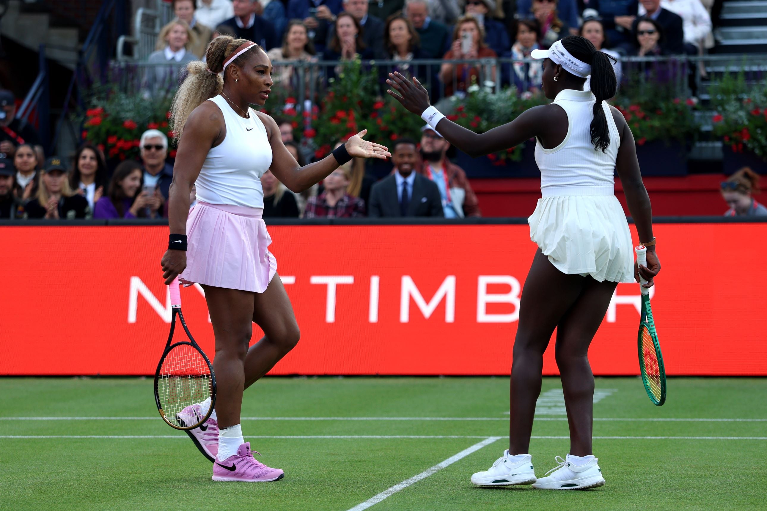 Tennis players Serena Williams and Victoria Mboko high five in celebration on the Andy Murray Arena in their round one match at the HSBC Championships