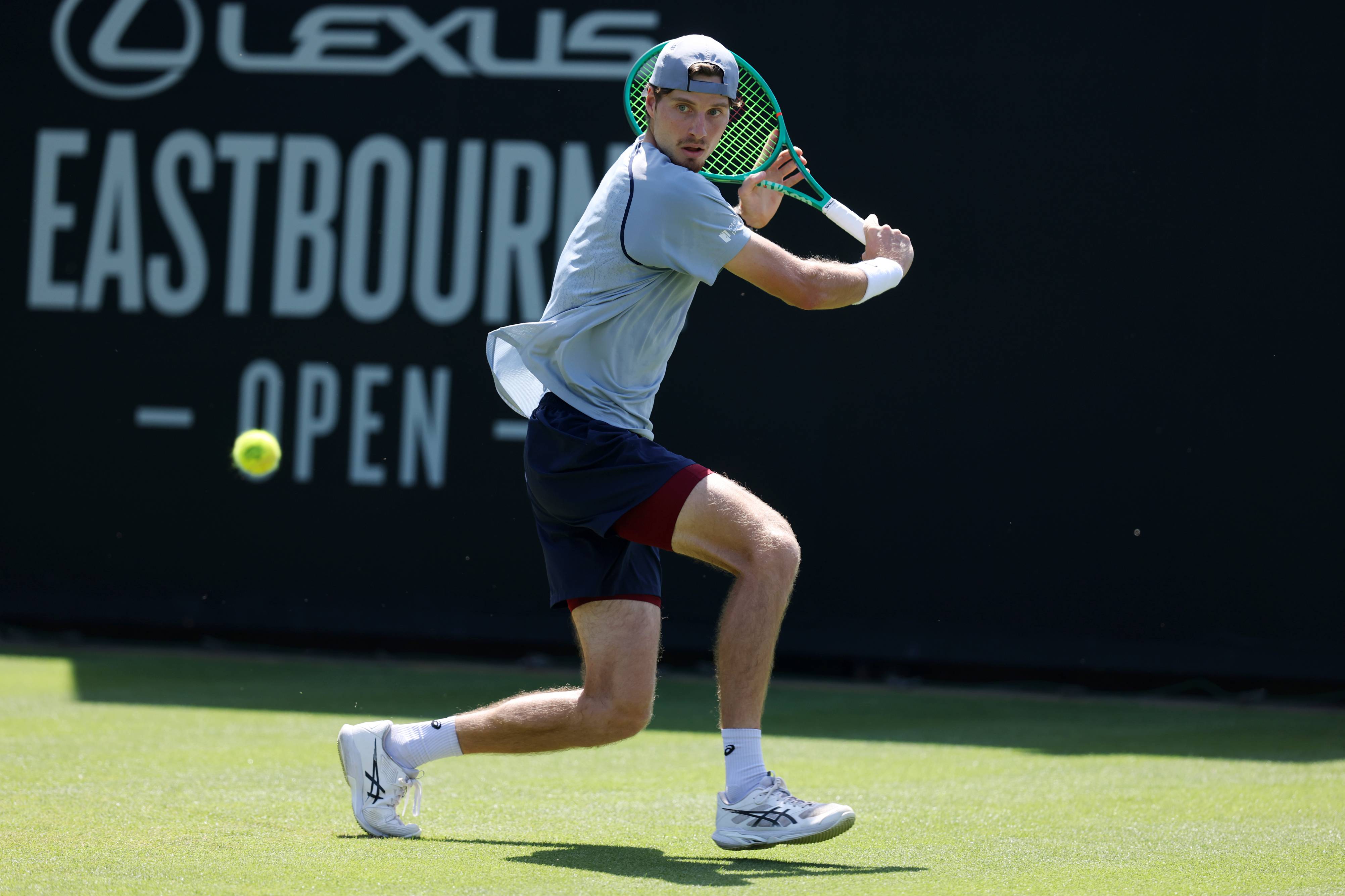 British tennis player Toby Samuel preparing to hit a backhand on a grass court at the Lexus Eastbourne Open