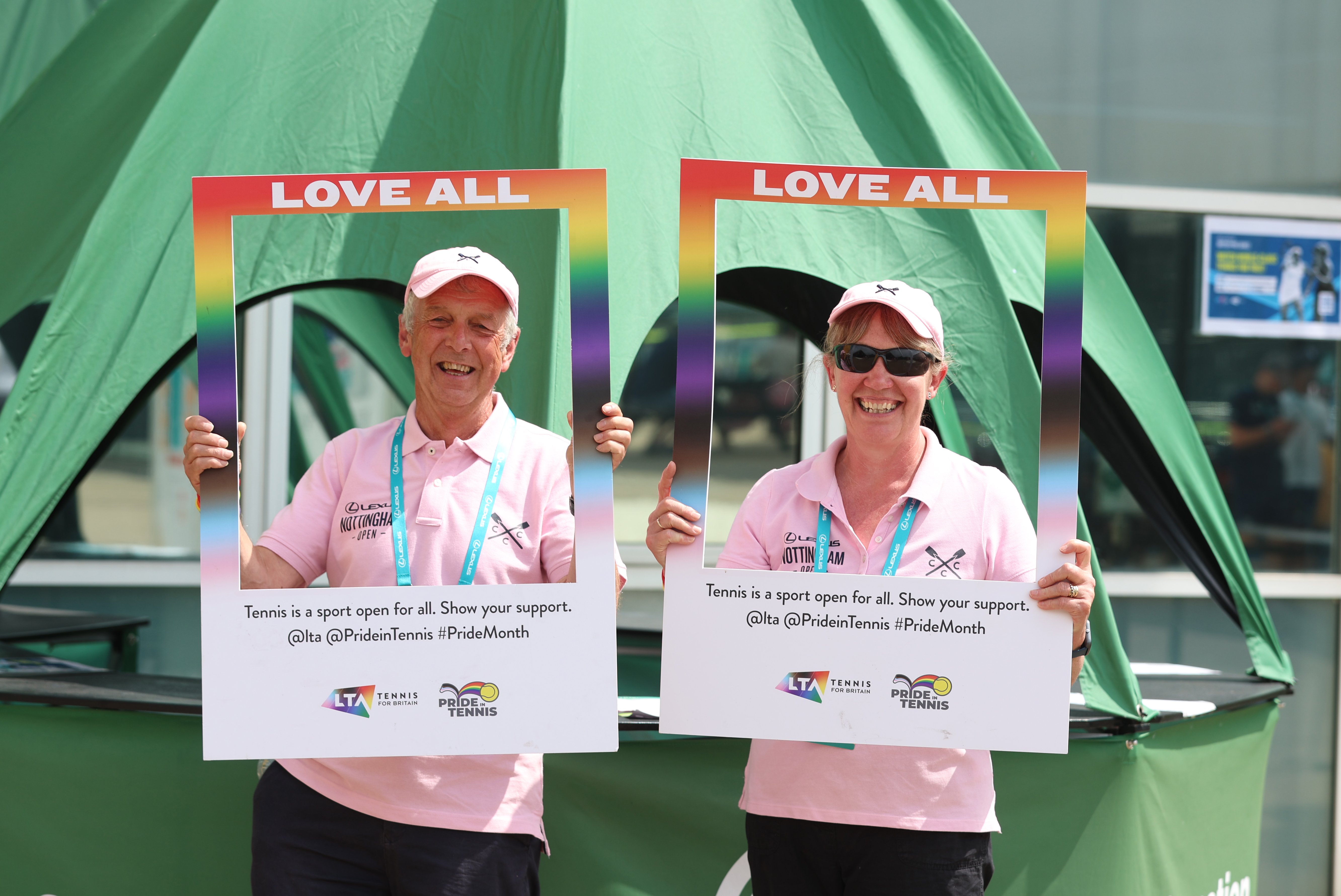 Two volunteers holding up a Love All sign