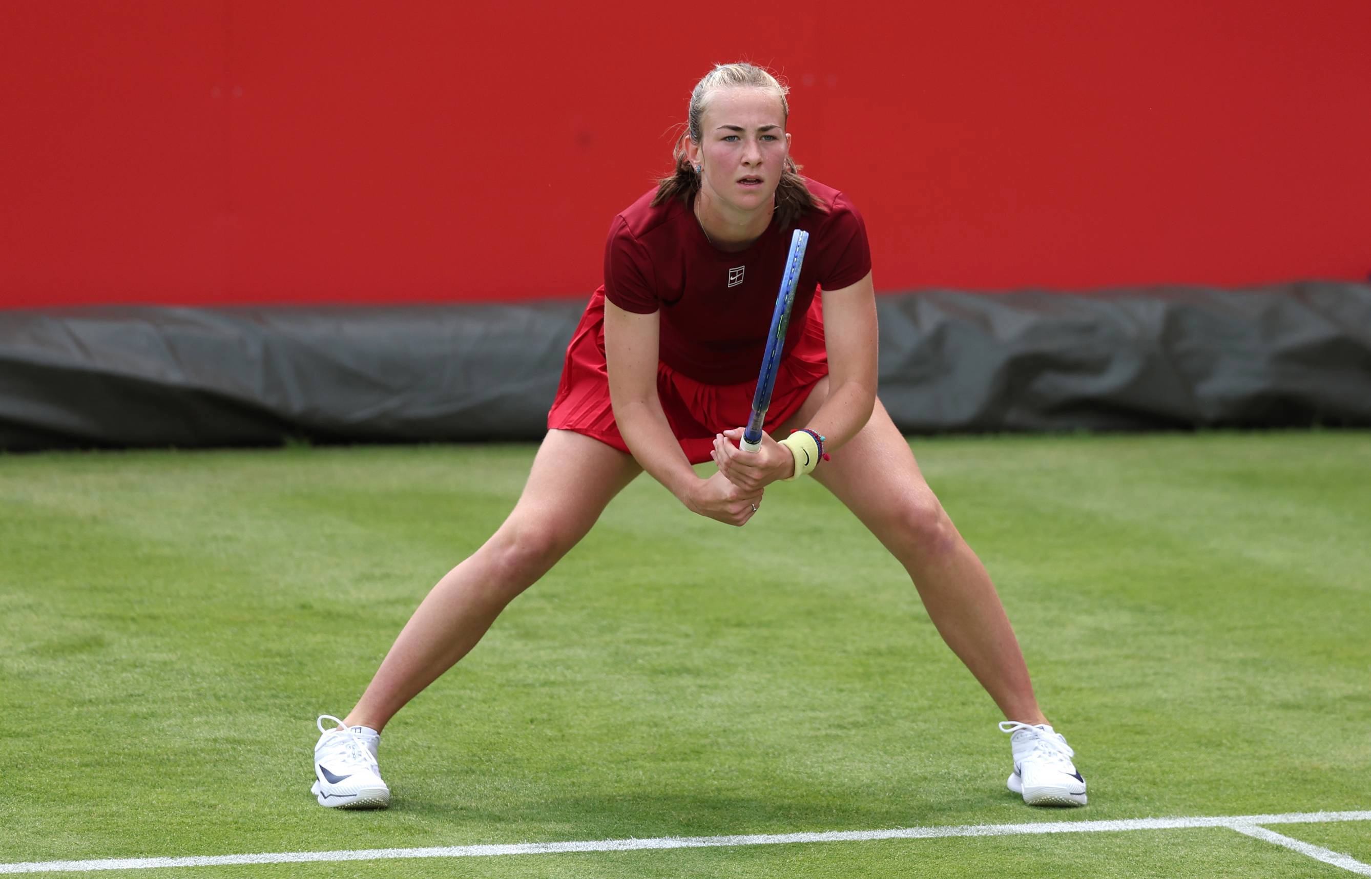 British tennis player Mika Stojsavljevic stood on a grass court while preparing to hit a return
